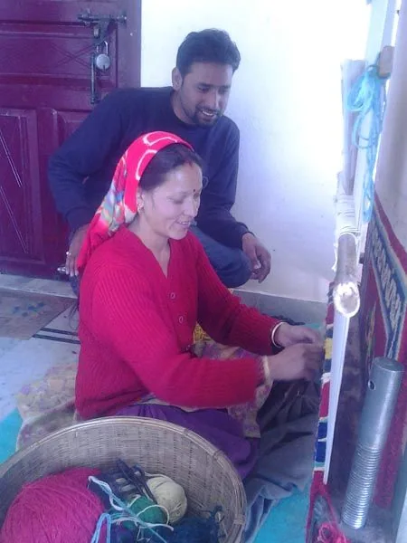 Woman in red working at a loom during the Bhotia Tribe programme