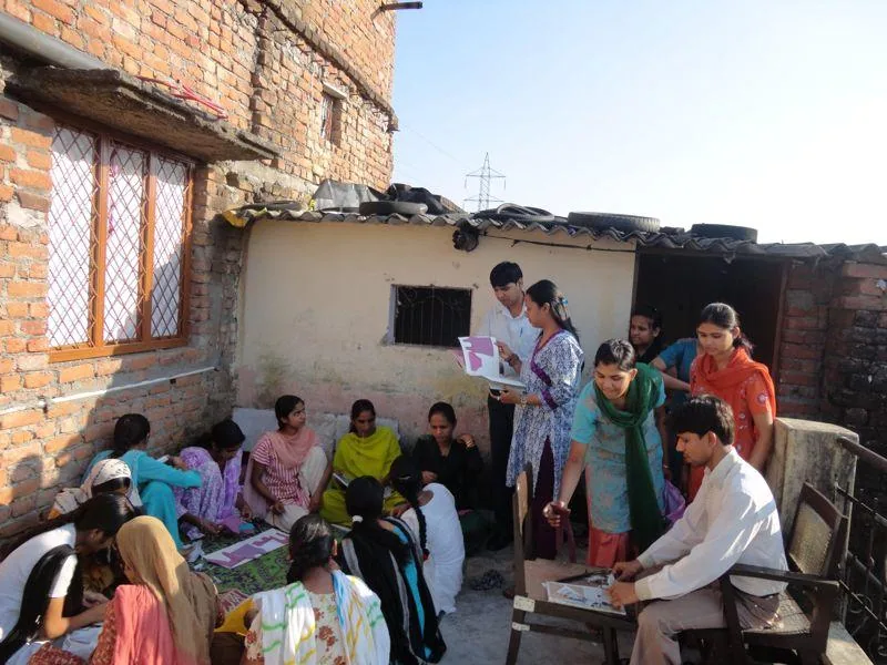 Programme facilitators meeting community members in an outdoor courtyard